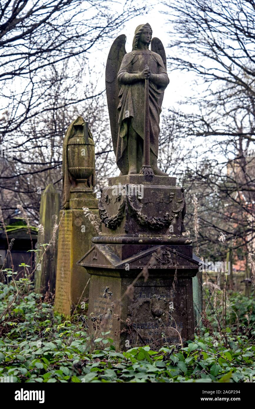 Figure of an angel stands on a monument in an overgrown and much neglected Dalry Cemetery in Edinburgh, Scotland, UK. Stock Photo
