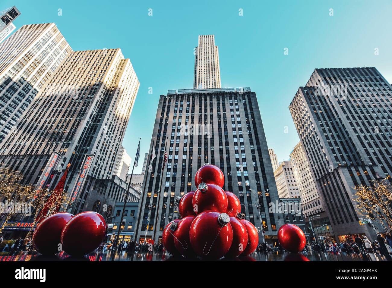 New York, NY, USA - November 30, 2019. Streets of Manhattan, Sixth Avenue with huge red Christmas decoration balls, near Radio City Music Hall, NY Stock Photo