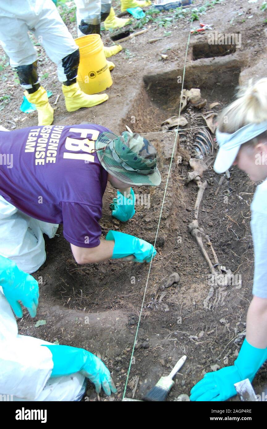 Human remains are excavated by FBI personnel at 'The Body Farm'. A body farm is a research facility where decomposition can be studied in a variety of settings. They were invented by anthropologist Dr. William Bass in 1971 at the University of Tennessee in Knoxville, Tennessee where Dr. Bass was interested in studying the decomposition of a human corpse from the time of death to the time of decay.[ Stock Photo