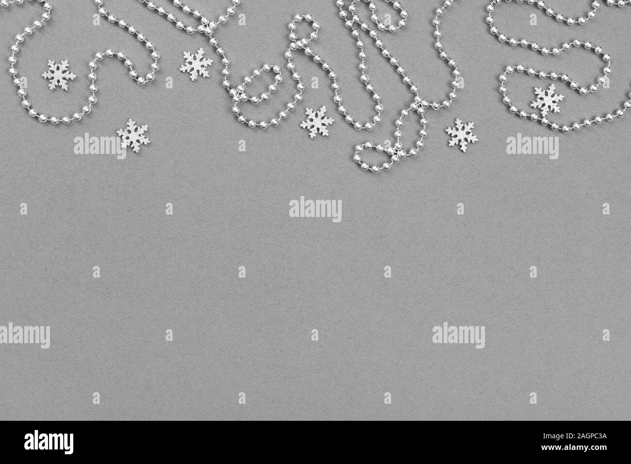 Christmas border with silver snowflakes and garland on grey background ...
