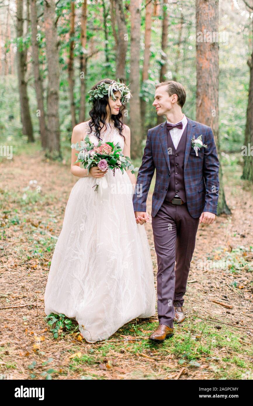 Happy Wedding Couple In Rustic Style Holding Hands Smiling And