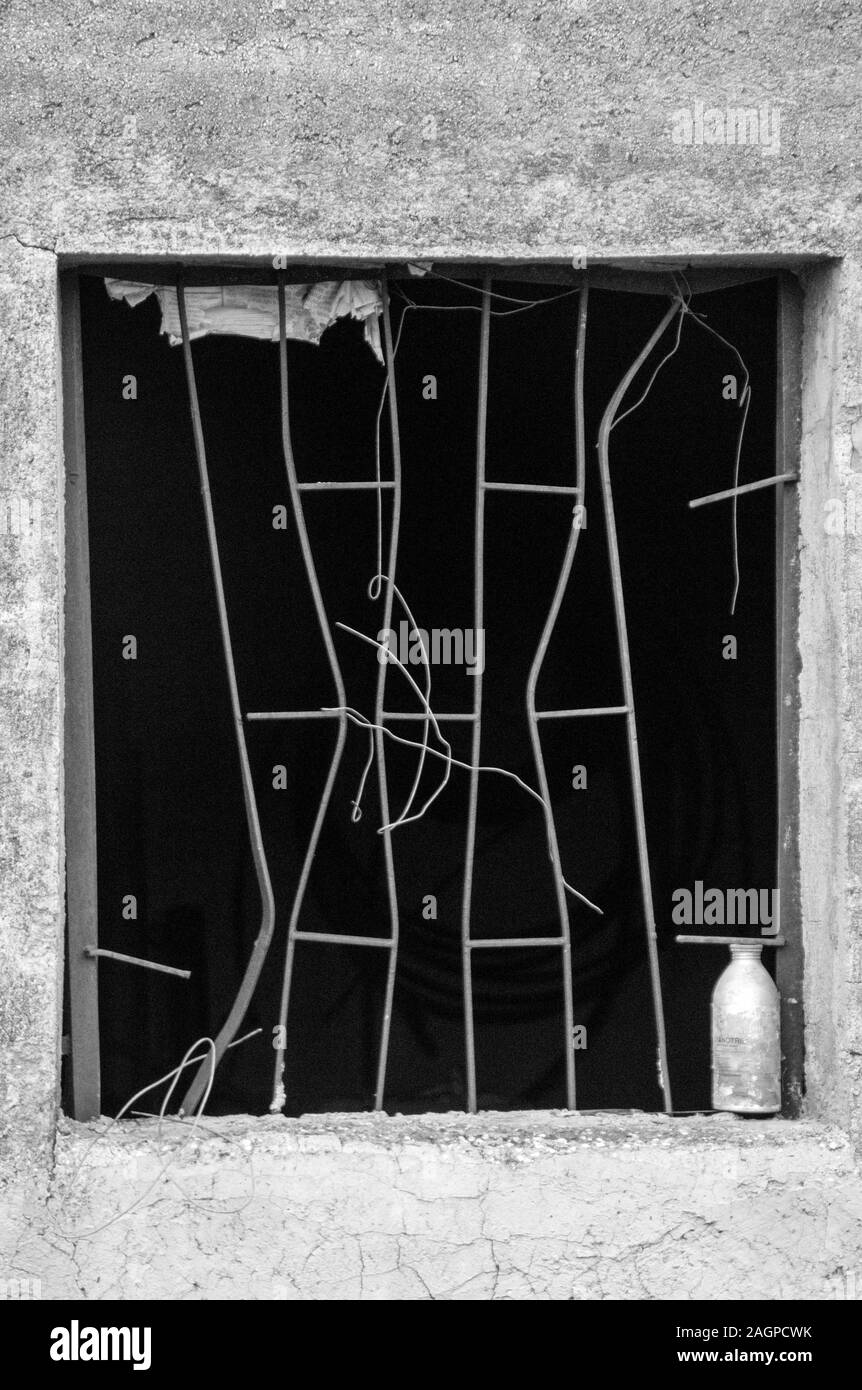 An old shed in the countryside of Sicily has a damaged window grill