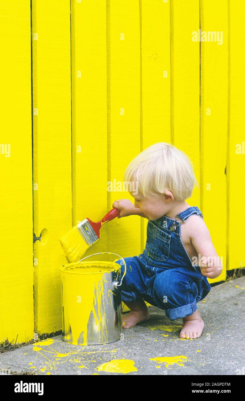 Two Year Old Boy Painting a Fence Yellow Stock Photo
