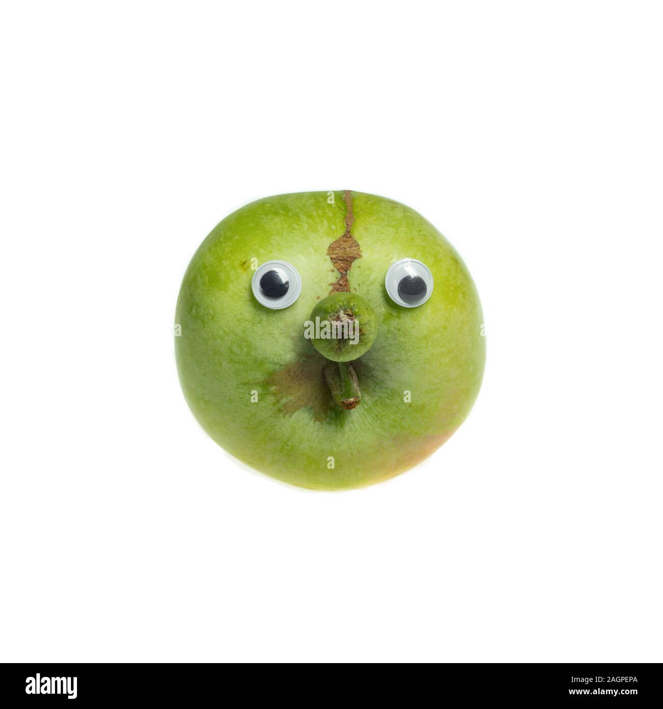 Trendy ugly food concept. Green funny apple with eyes isolated on white