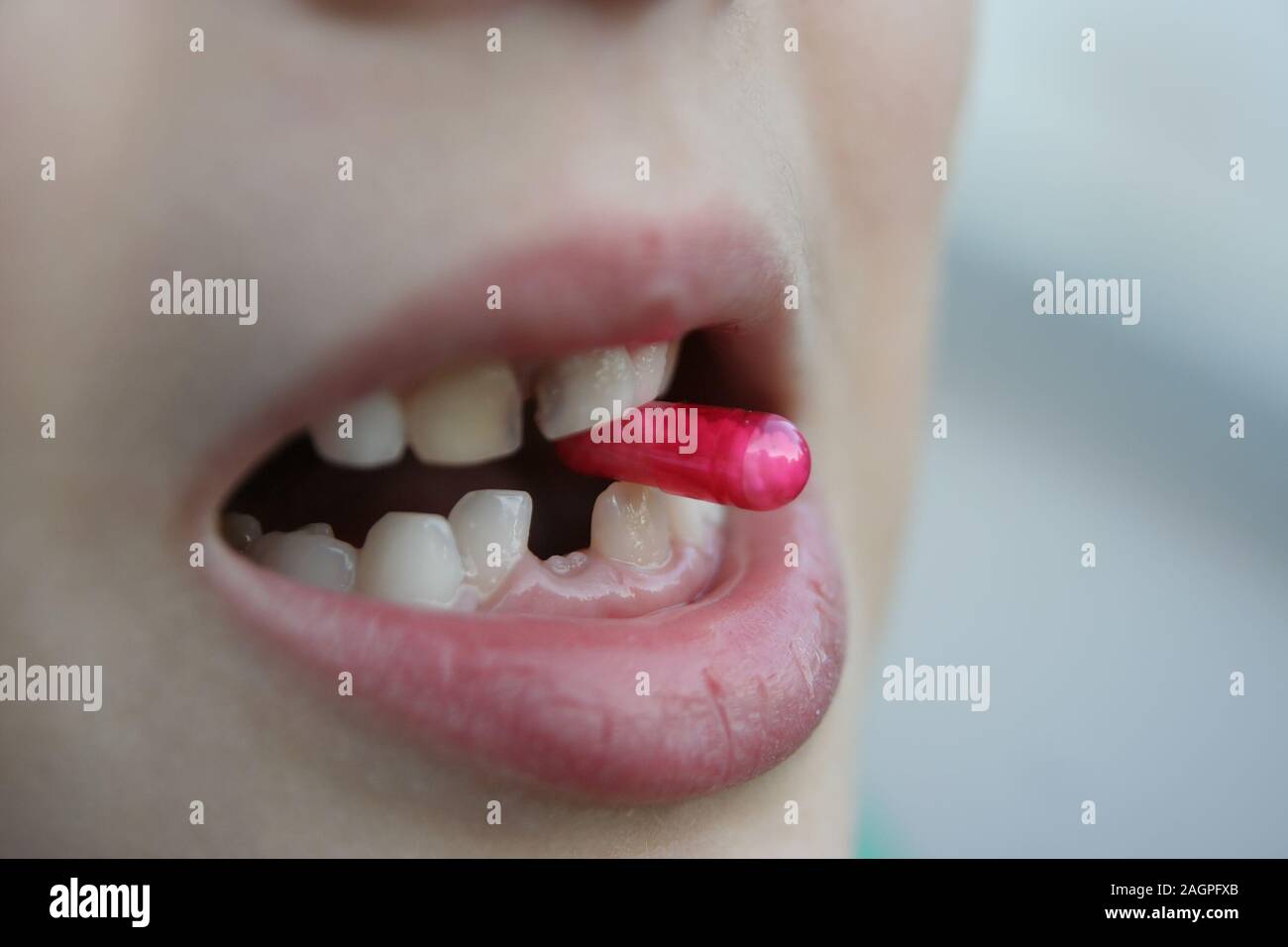 Kid taking pills. Kid taking antibiotics. Child using medical pills. Stock Photo