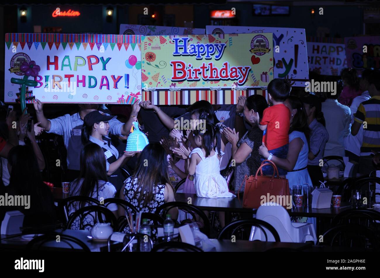 Cambodian Birthday Party, waitress delivers birthday cake, Spark & Tawandang German Brewery, Phnom Penh, Cambodia. © Kraig Lieb Stock Photo