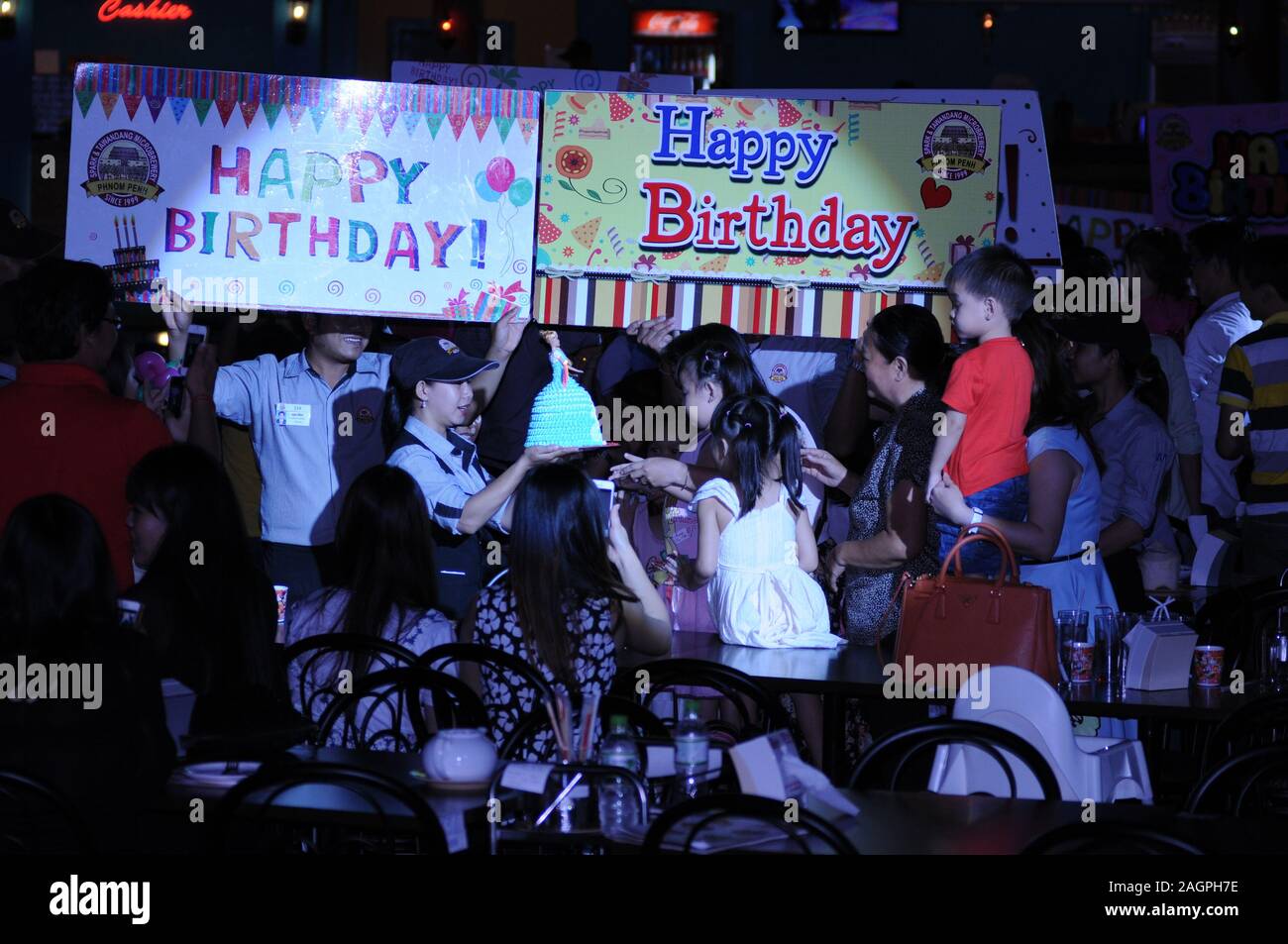 Cambodian Birthday Party, waitress delivers birthday cake, Spark & Tawandang German Brewery, Phnom Penh, Cambodia. © Kraig Lieb Stock Photo