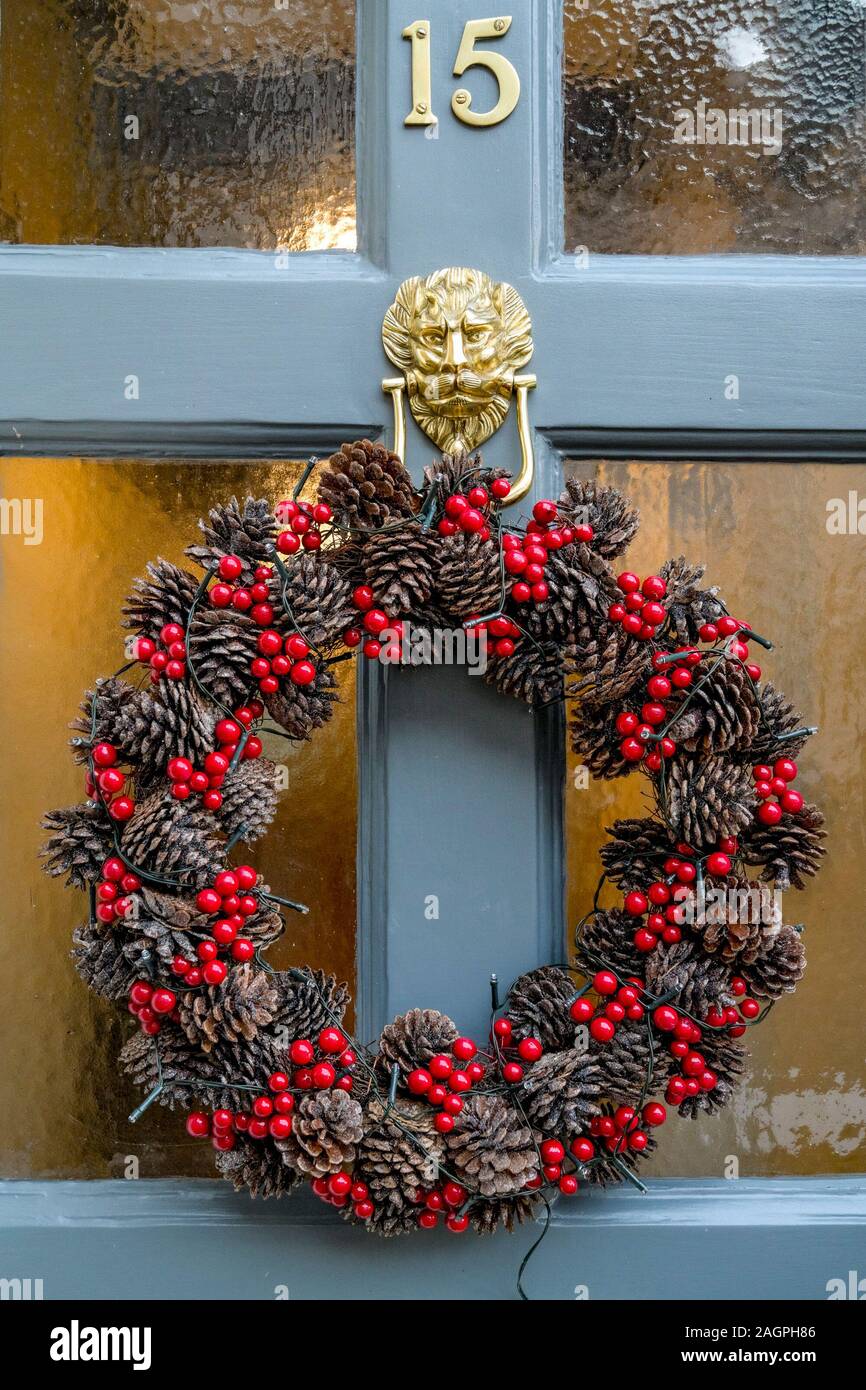 Christmas holiday wreath with pine cones and red berries, on door ...