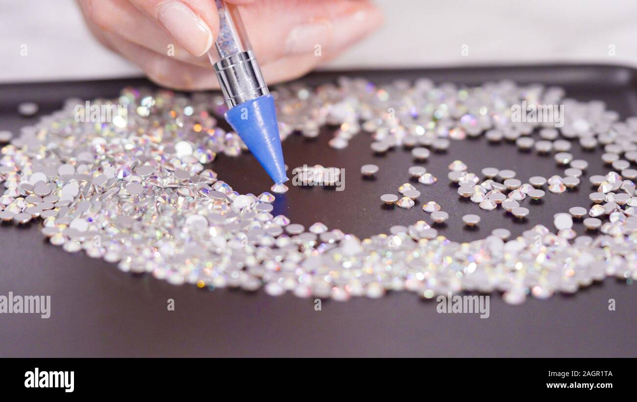 An abundance of white rhinestones with flat back on a black board ready for  a craft project Stock Photo - Alamy