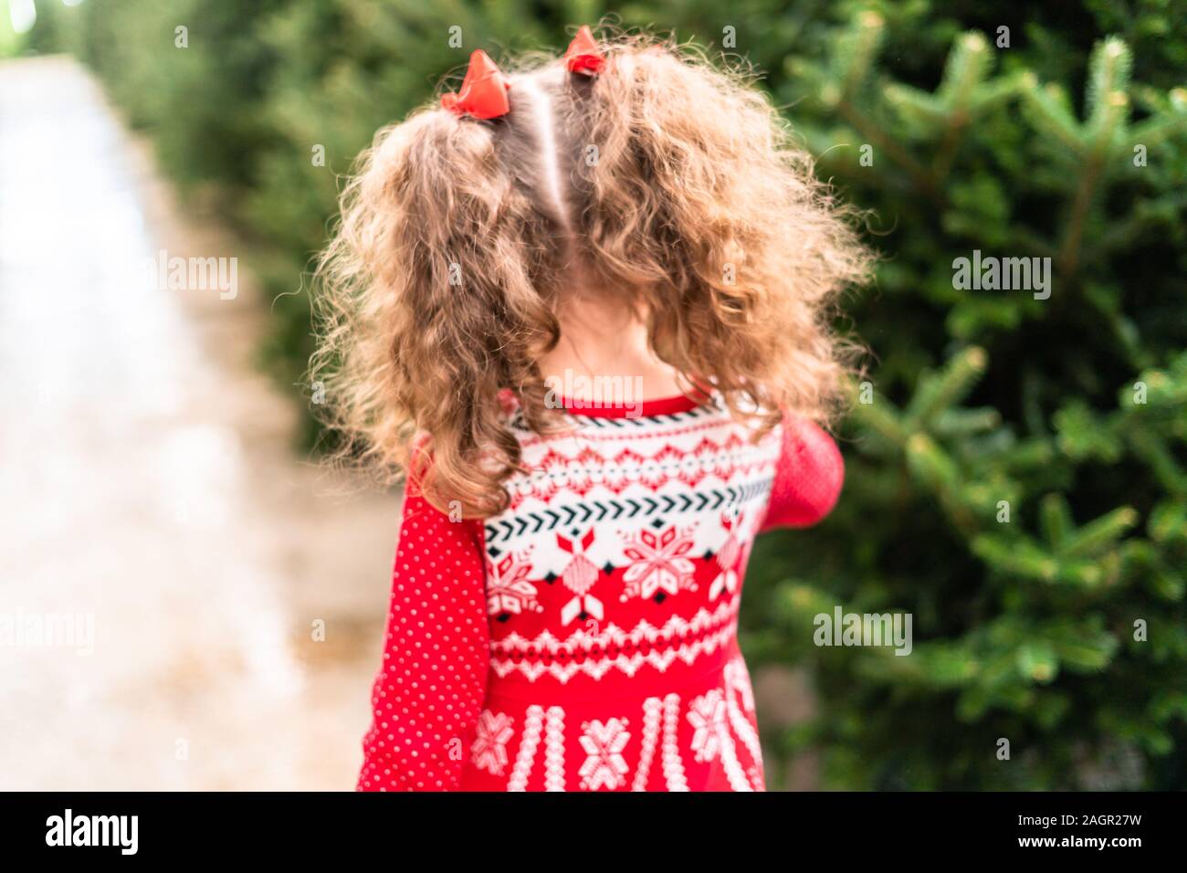 Little girl in red dress at the Christmas tree farm Stock Photo - Alamy