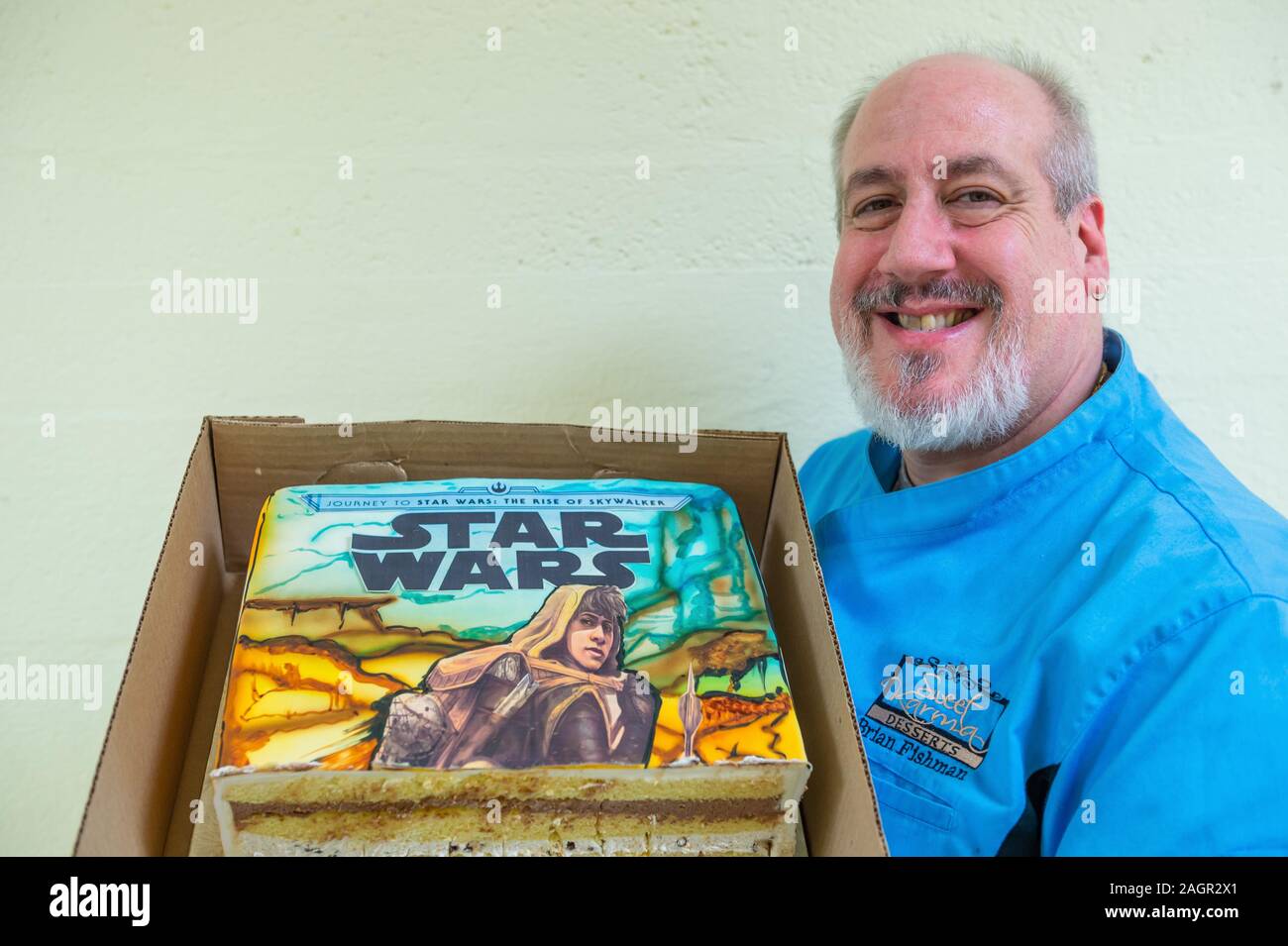 Merrick, New York, USA. 20th Dec, 2019. Baker BRIAN FISHMAN holds partly  eaten cake he decorated with cover of his childhood friend Kevin Shinick's  book STAR WARS: FORCE COLLECTOR during book signing