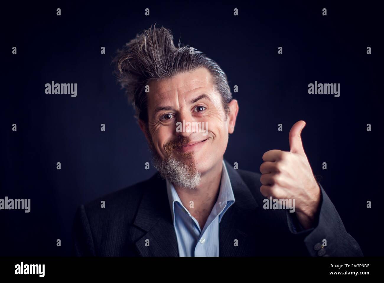 Half bearded funny man wearing suit showing thumb up gesture in front of black background. People and skin care concept Stock Photo