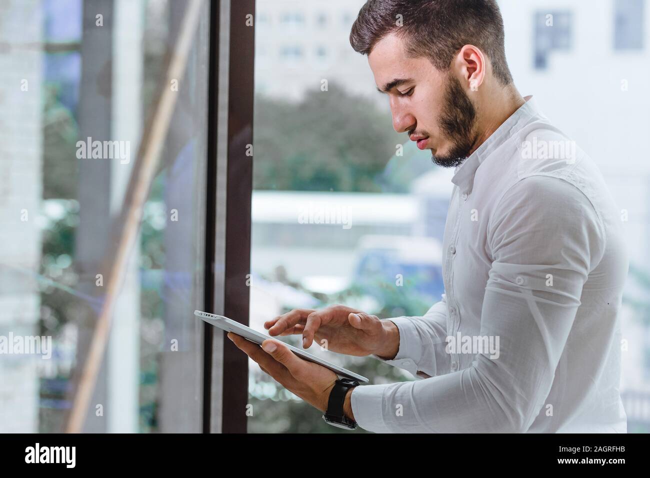 closeup of young arab ethnency man using tablet pc indoor Stock Photo