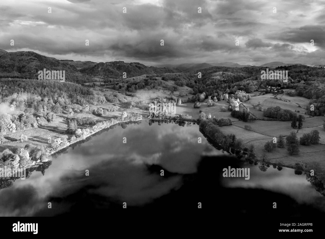 Stunning aerial drone landscape images over Coniston Water at sunrise on beautiful Autumn Fall morning in black and white Stock Photo