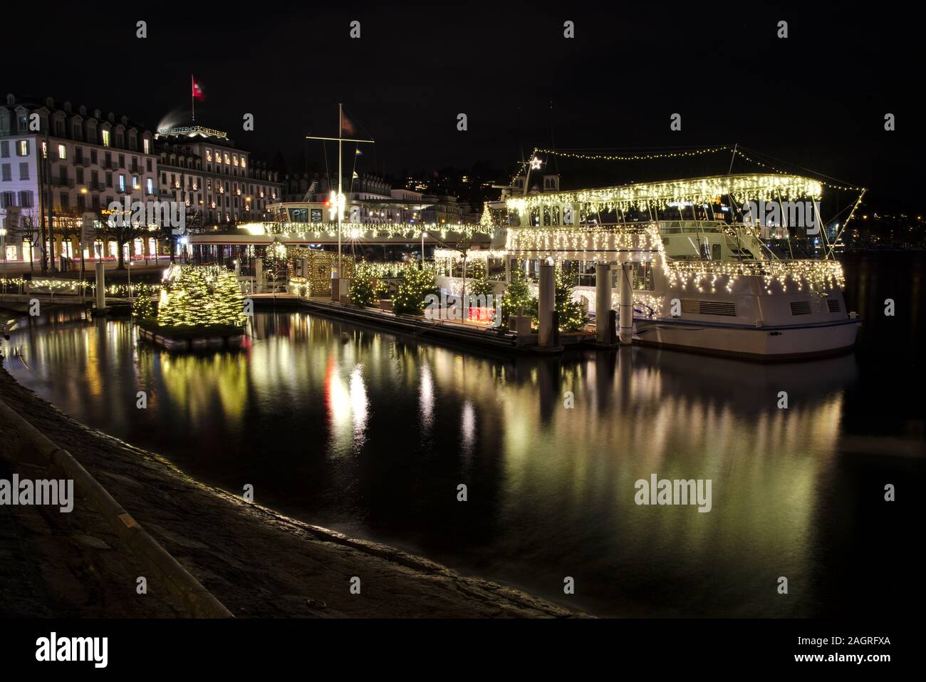 Boat decorated with Christmas lights in front of the Schwanenplatz in Lucerne, Switzerland, during night Stock Photo