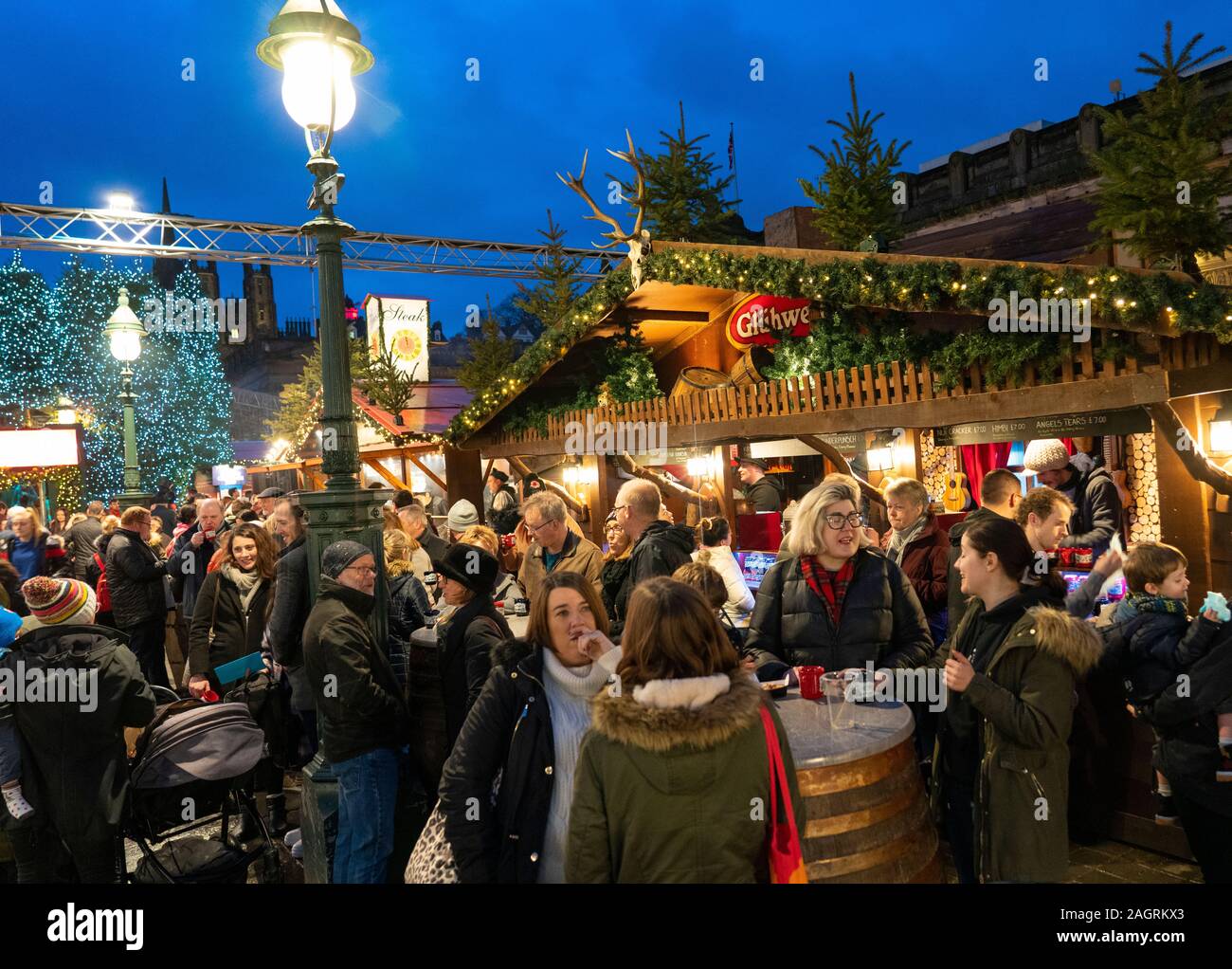 View of people eating and drinking at stalls in busy Edinburgh Christmas Market in West Princes Street gardens in Edinburgh, Scotland, UK Stock Photo