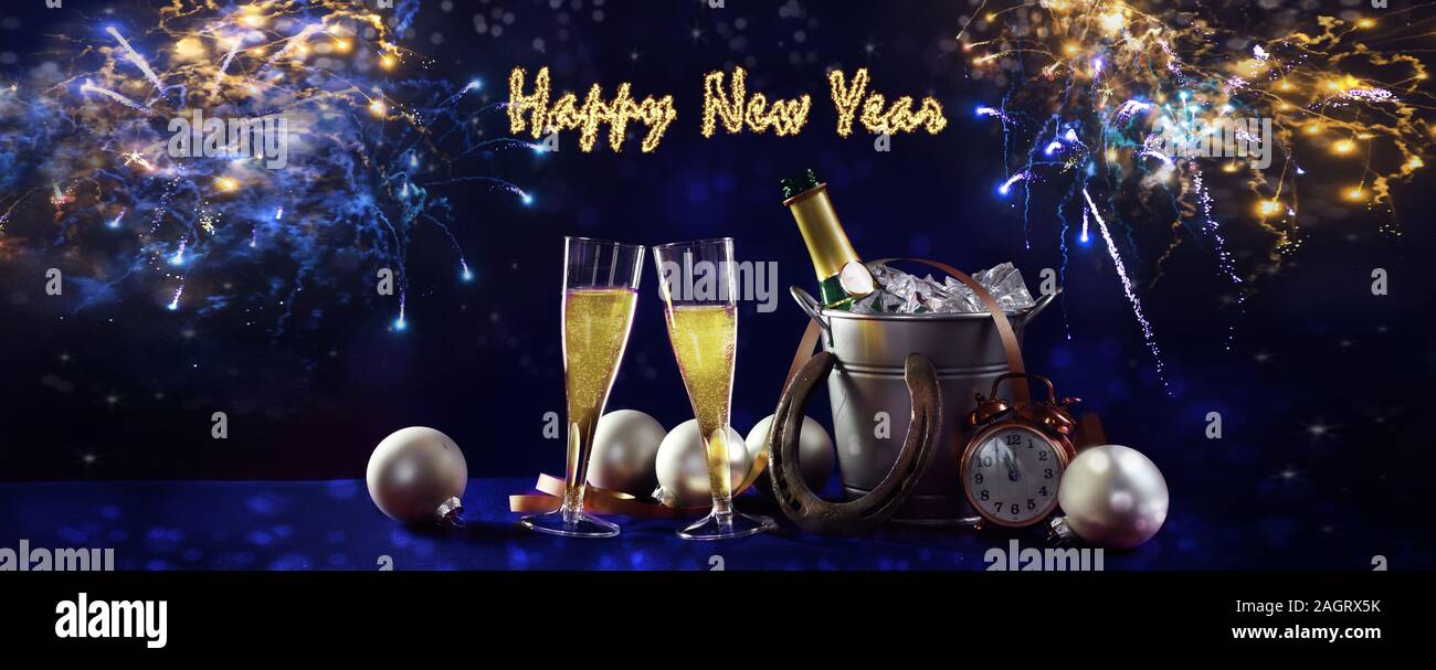 Happy New Year banner with champagne bottle and glasses, christmas  decorations and fireworks against a dark blue background in panoramic  format Stock Photo - Alamy