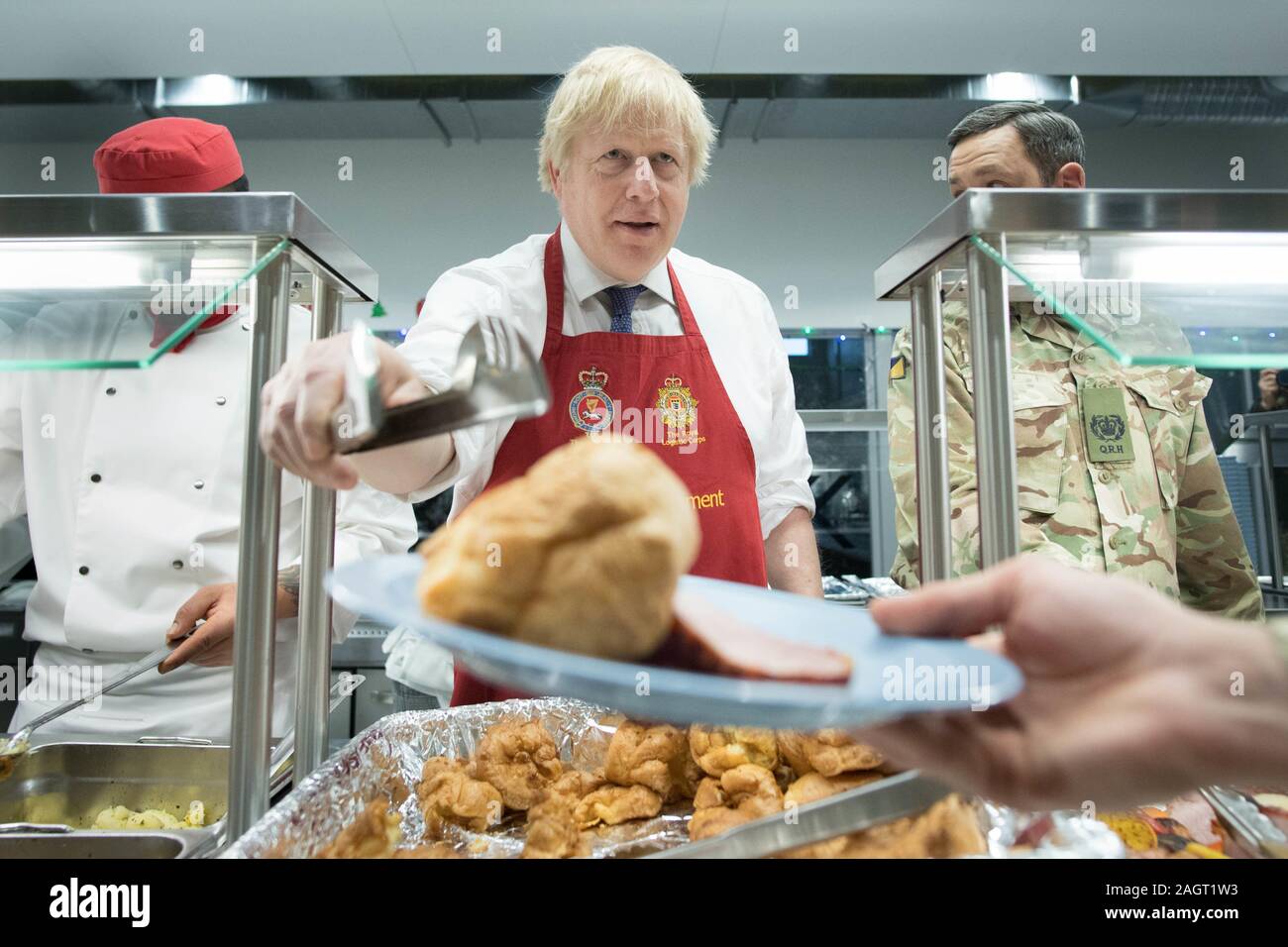 Prime Minister Boris Johnson serves Christmas lunch to British troops stationed in Estonia during a one-day visit to the Baltic country. PA Photo. Picture date: Saturday December 21, 2019. The Prime Minister thanked the servicemen and women for their work as he joined them for lunch at the Tapa military base near the capital Tallinn. The base is home to 850 British troops from the Queen's Royal Hussars who lead the Nato battlegroup along with personnel from Estonia, France and Denmark. See PA story POLITICS Estonia. Photo credit should read: Stefan Rousseau/PA Wire Stock Photo