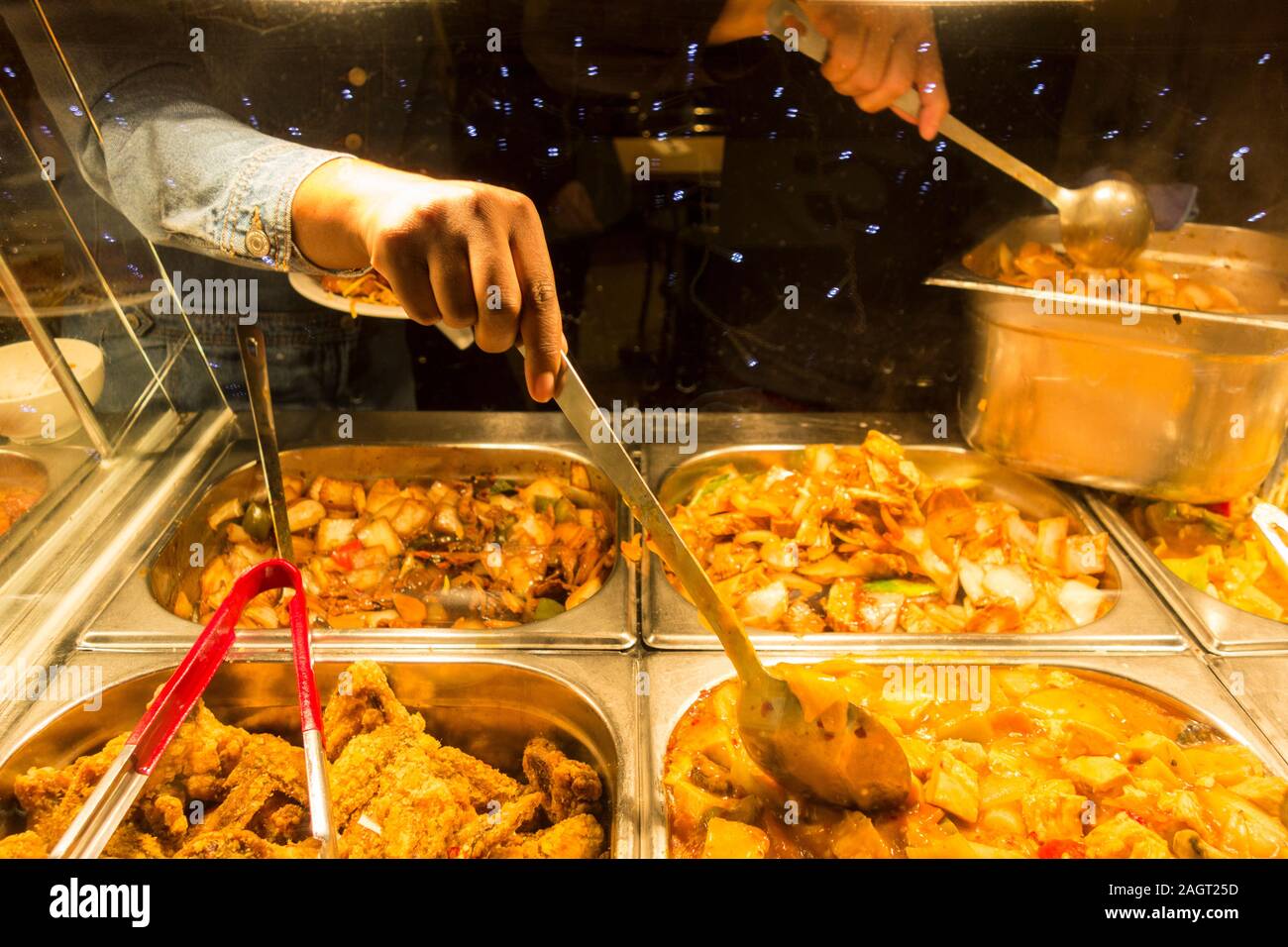 Customers serving themselves in a Chinese buffet restaurant in Chinatown, Soho, London, UK Stock Photo