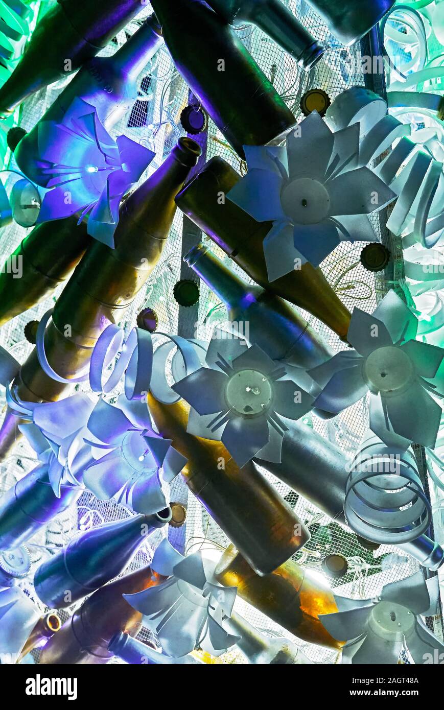 Close-up of a unusual Christmas decoration of recycled plastics and empty bottles combined with cold flower shaped lights Stock Photo