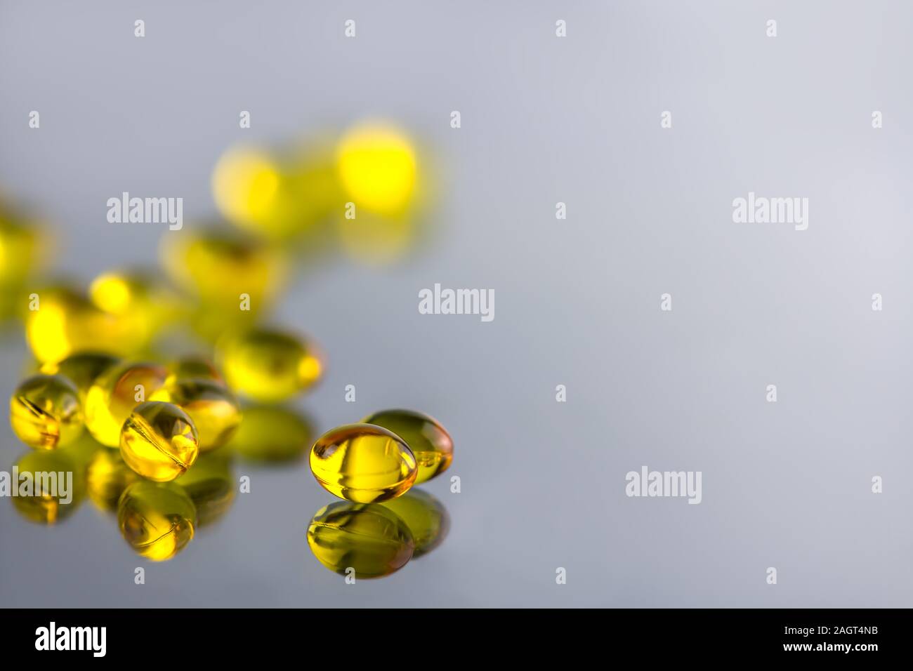 gelatinous yellow capsule on a gray background. health. vitamins D, E