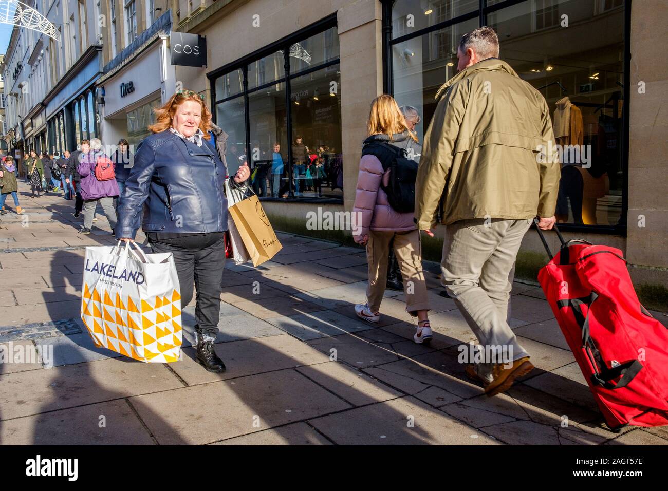 Bath, Somerset, UK. 21st December, 2019. Shoppers in Bath city centre are pictured as they visit the shops on the last Saturday before Christmas. The last Saturday before Christmas has become known as ‘Panic Saturday' and many stores have  reduced prices to attract last minute customers. Credit: Lynchpics/Alamy Live News Stock Photo