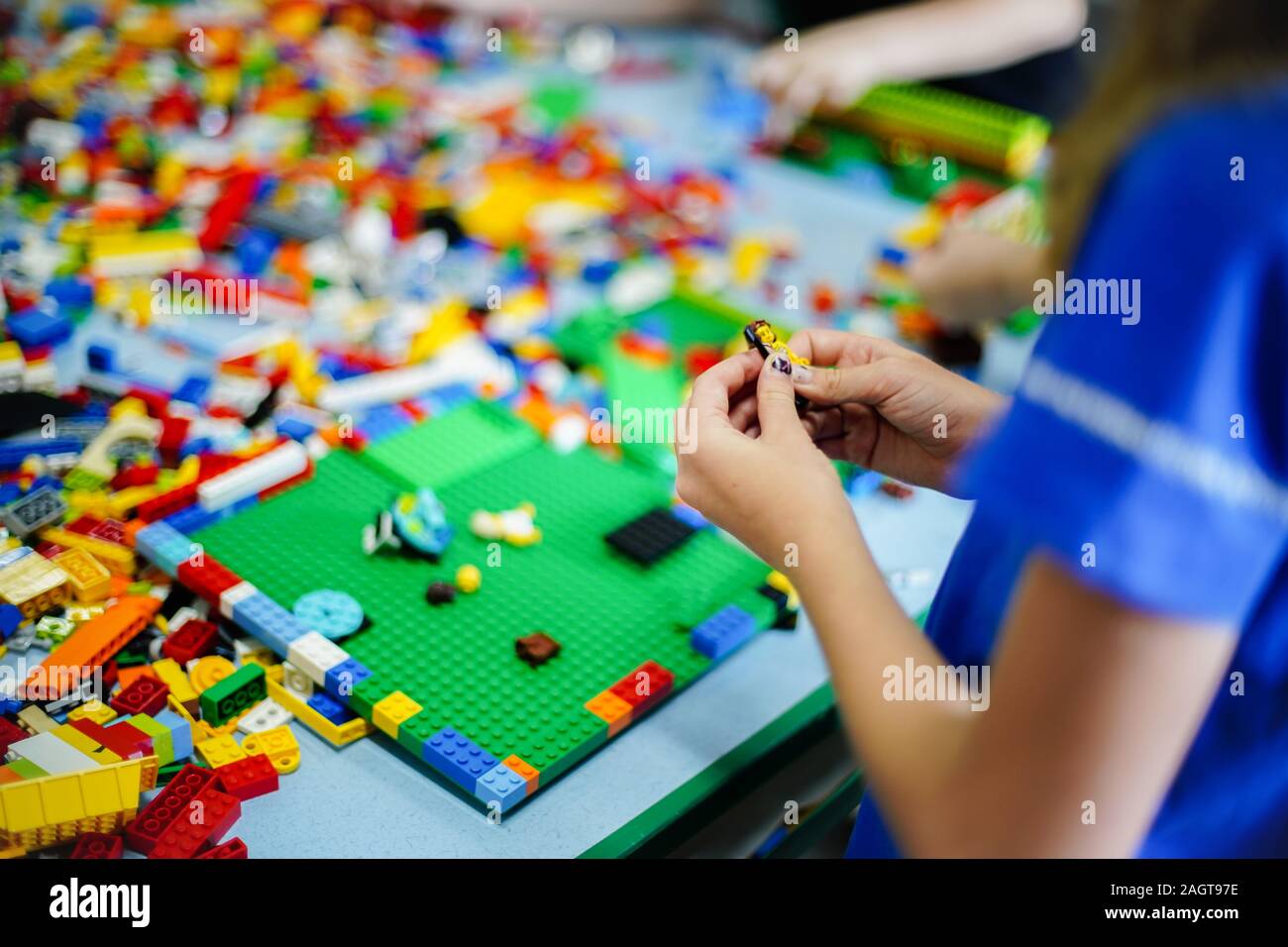 Little kid playing with lots of colorful plastic blocks indoor ...