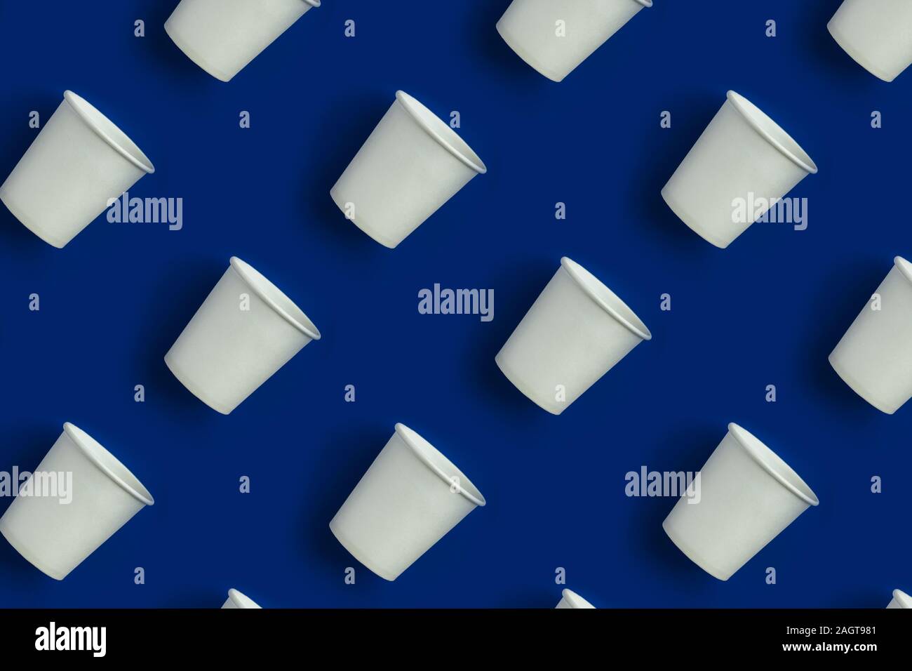 Pattern made with white paper cups on blue background. Stock Photo