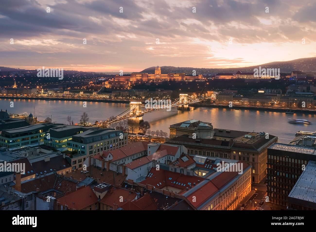 Sunset cityscape from Budapest with Danube river, Szechenyi chain bridge, Buda caslle, Varkert bazaar  and sandor palace. Stock Photo