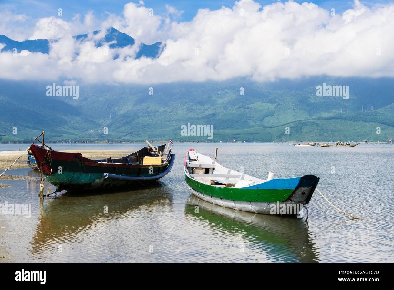 Small traditional fishing boats on Lap An Lagoon with mountains beyond in Bach Ma National Park. Lang Co, Phu Loc, Thua Thien Hue, Vietnam, Asia Stock Photo