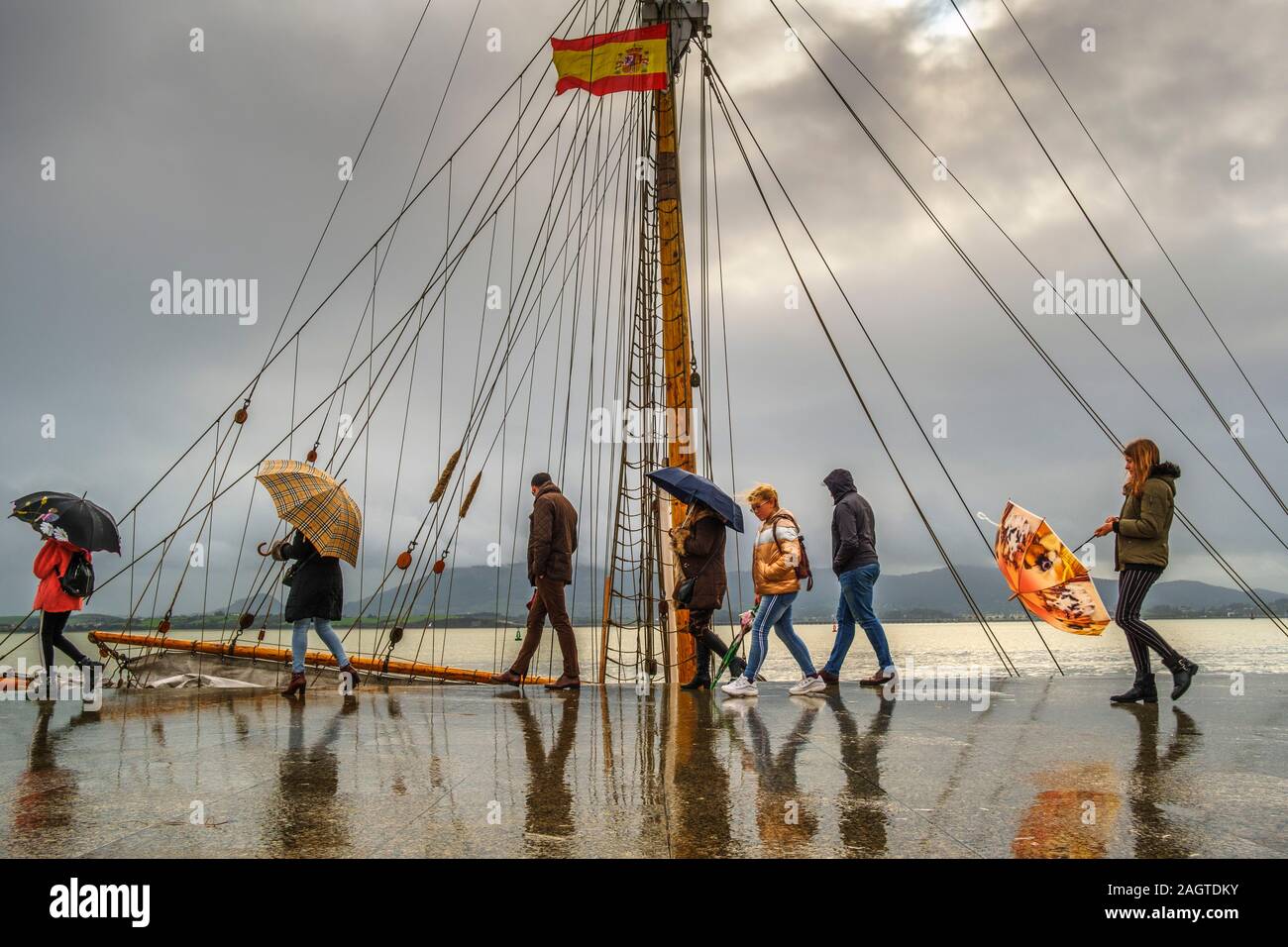 People walking on a rainy day along the seafront promenade Muelle Calderon, Paseo de Pereda. Cantabrian Sea Santander. Cantabria Spain. Europe Stock Photo