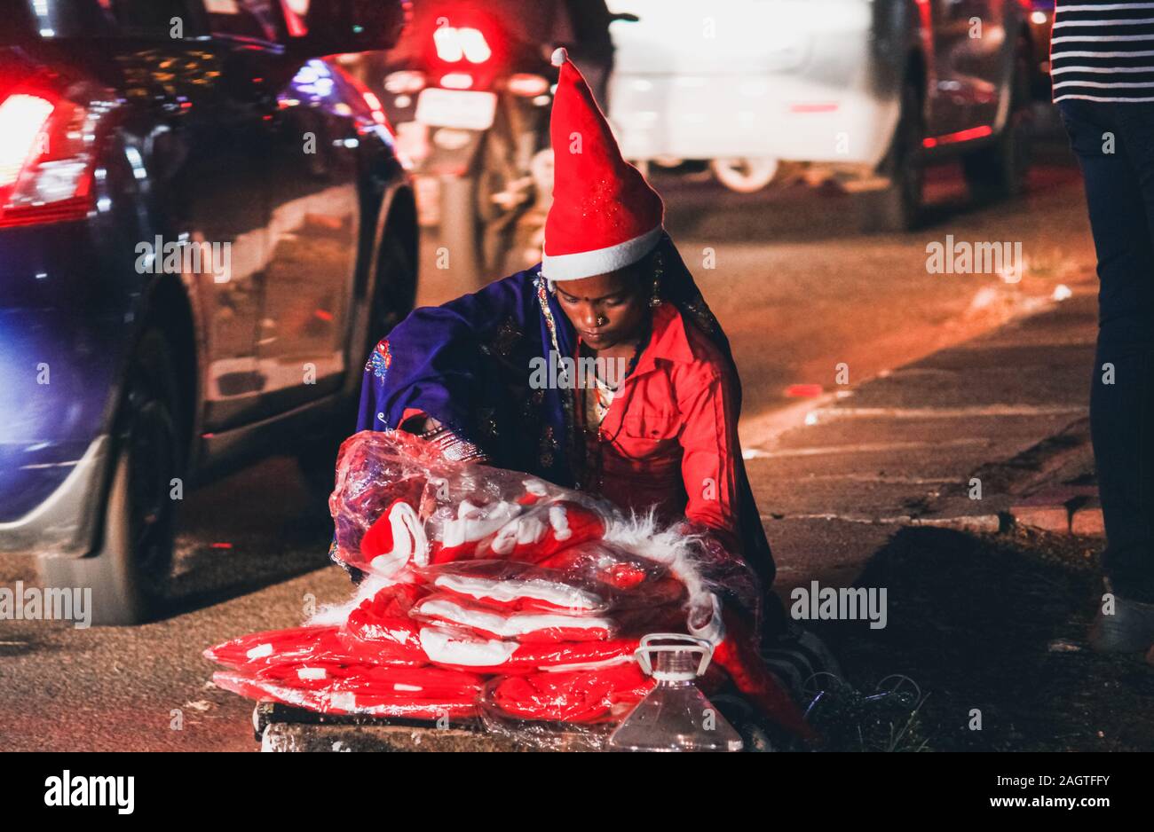 Beautiful Lady hawker with Santa clause costume on street at night Stock Photo