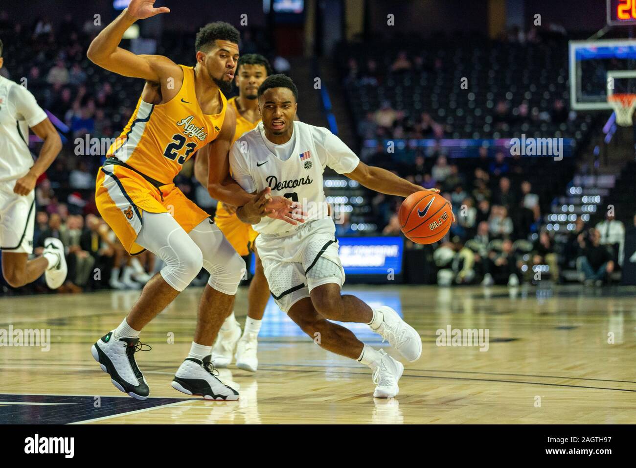 Winston-Salem, NC, USA. 21st Dec, 2019. North Carolina A&T Aggies forward Devin Haygood (23) defends the drive from Wake Forest Demon Deacons guard Brandon Childress (0) during the first half of the NCAA Basketball matchup at LJVM Coliseum in Winston-Salem, NC. (Scott Kinser/Cal Sport Media). Credit: csm/Alamy Live News Stock Photo