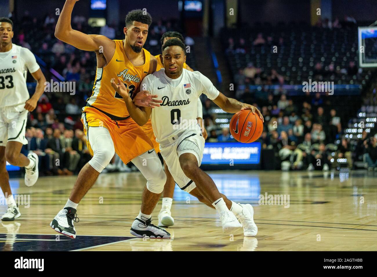 Winston-Salem, NC, USA. 21st Dec, 2019. North Carolina A&T Aggies forward Devin Haygood (23) defends the drive from Wake Forest Demon Deacons guard Brandon Childress (0) during the first half of the NCAA Basketball matchup at LJVM Coliseum in Winston-Salem, NC. (Scott Kinser/Cal Sport Media). Credit: csm/Alamy Live News Stock Photo