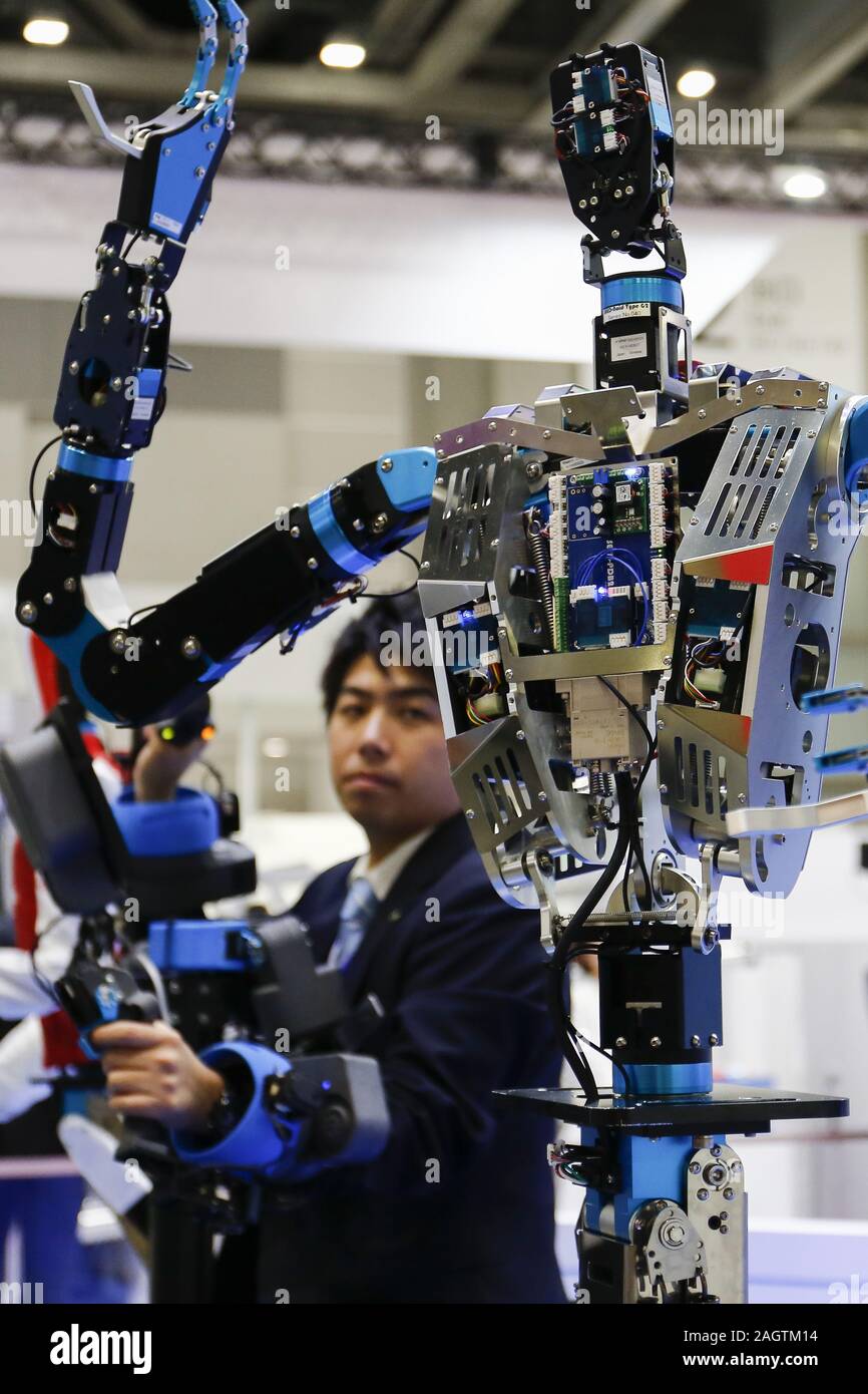 Tokyo, Japan. 21st Dec, 2019. A man controls a life-sized humanoid robot  SEED-Noid during the International Robot Exhibition 2019 (iREX2019) in Tokyo  Big Sight. The IREX is the largest robot trade fair