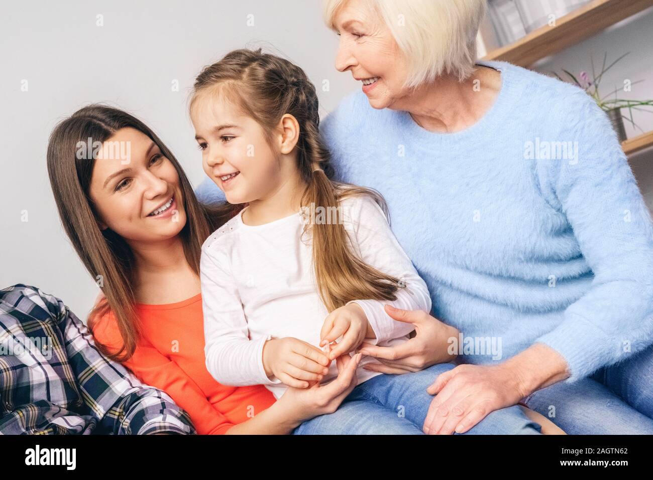 Mom and grandmother hug a little girl Stock Photo - Alamy