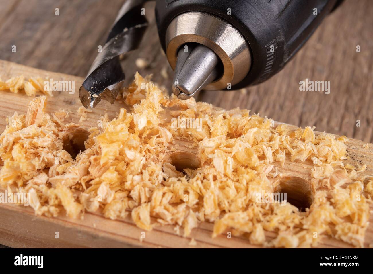 Drilling holes in a piece of wood. Countersinking the hole for wood screws. Dark background