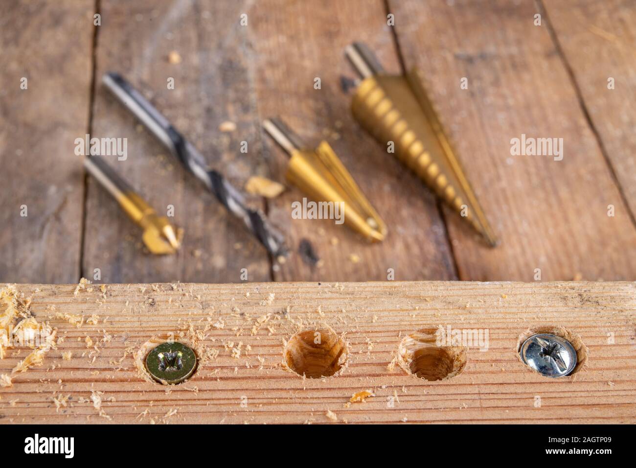 Drilling holes in a piece of wood. Countersinking the hole for wood screws. Dark background