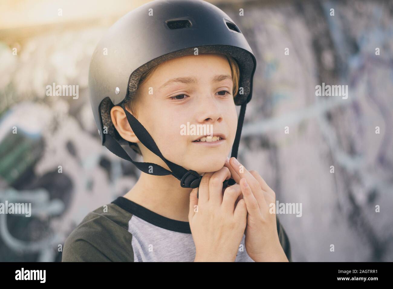 Portrait of trendy young skater at the skatepark wearing helmet