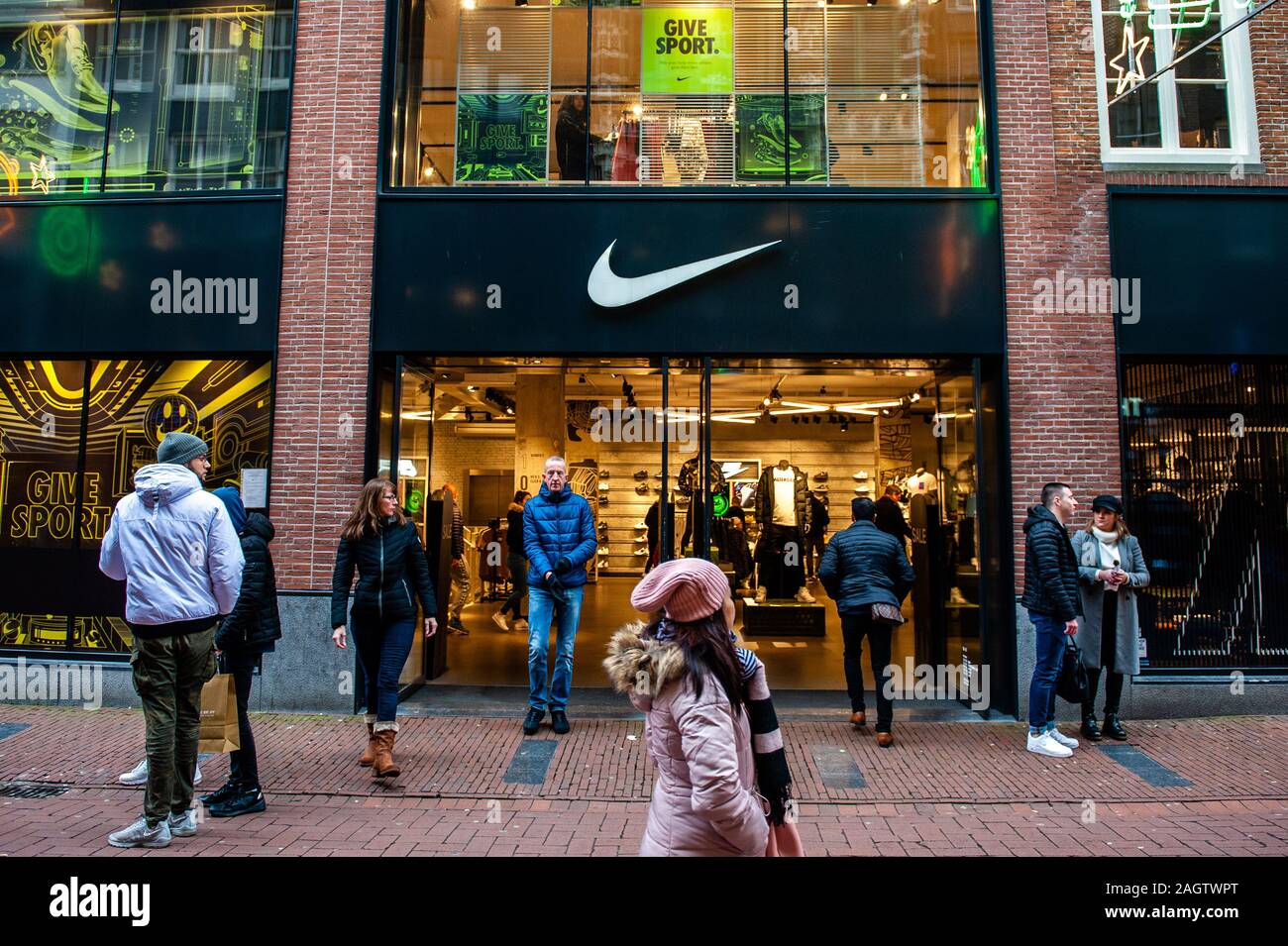 Shoppers walk past the NIKE store.This day marks the end of the shopping  season that began on Black Friday. In Amsterdam, thousands of tourists and  people took the principal shopping streets in