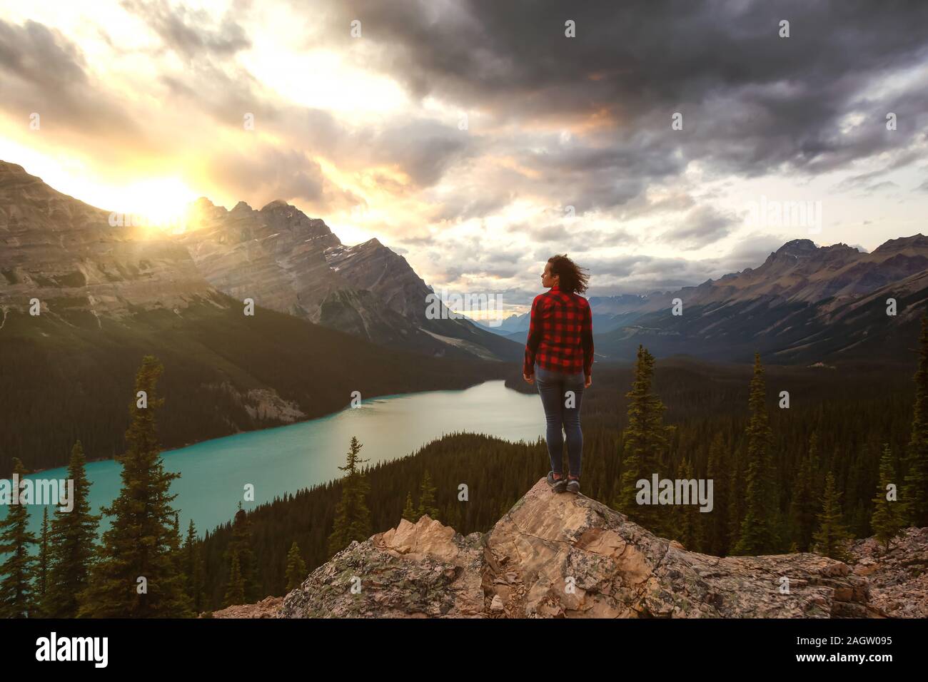 Adventurous girl standing on the edge of a cliff overlooking the ...