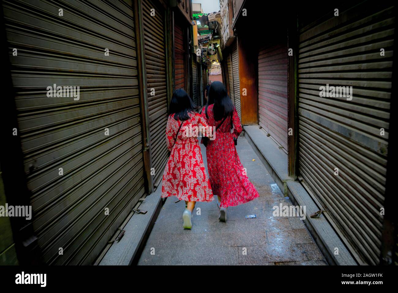 November 2019, LUXOR, EGYPT - Moslem People of Egypt go shopping at Luxor  Souq - two women wear bright red dresses from behind Stock Photo - Alamy