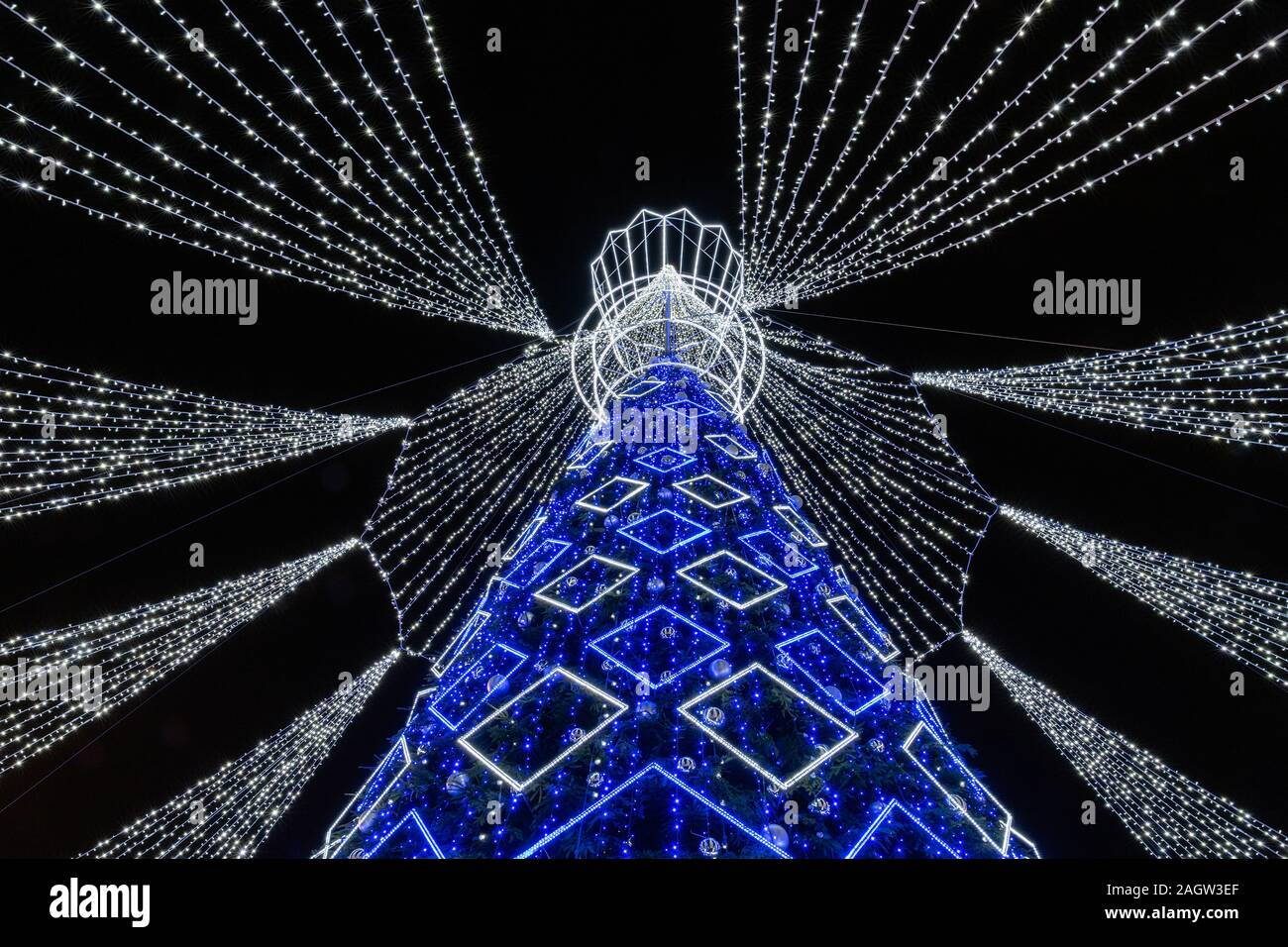 The top of a decorated Christmas tree  at night in Vilnius, Lithuania. Christmas tree is depicted as a chess queen and its top is similar to a crown. Stock Photo
