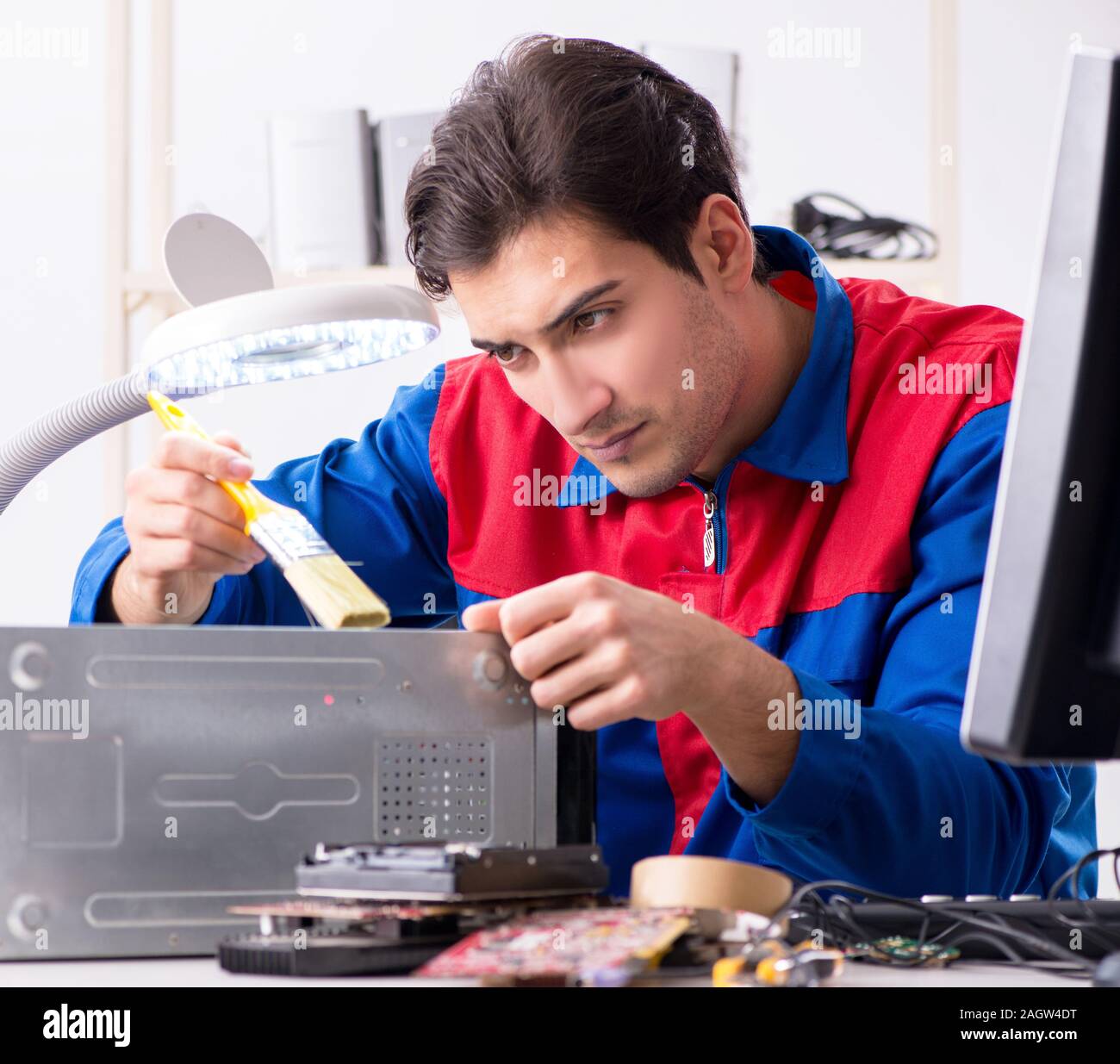 The professional repairman repairing computer in workshop Stock Photo ...