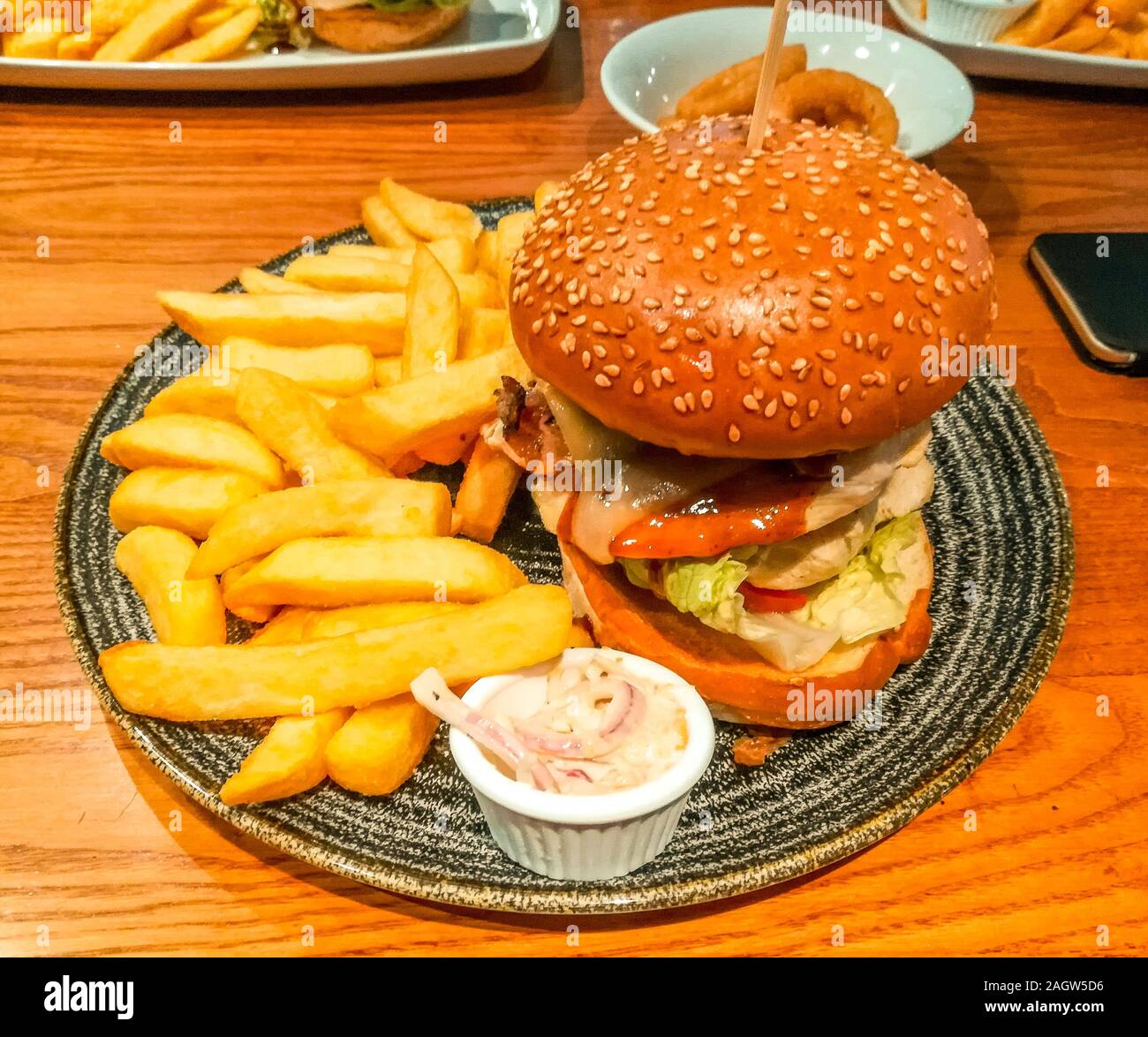 A typical British pub lunch meal. Burger, chips and coleslaw. Stock Photo