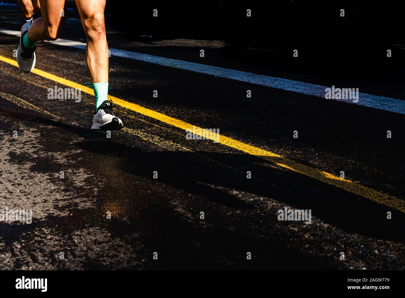 Running athletes have powerful quadriceps and calf muscles for running on asphalt Stock Photo