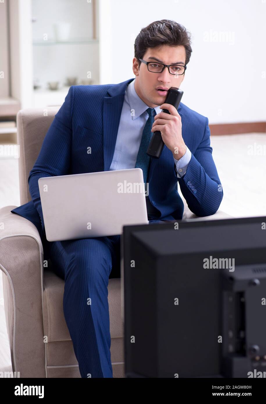 The businessman watching tv in the office Stock Photo Alamy