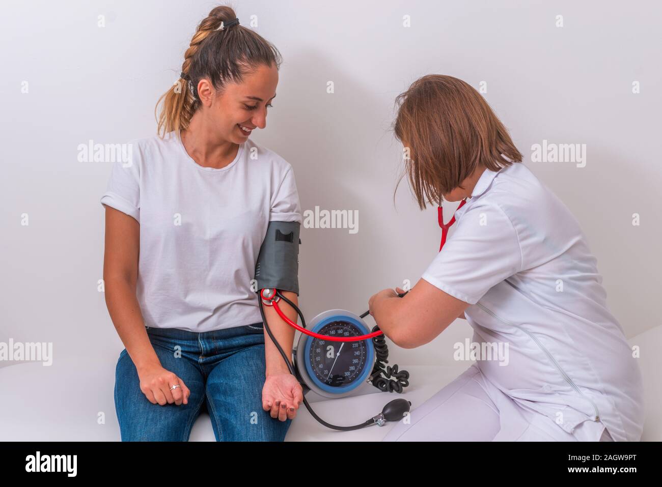 Female doctor measuring the blood pressure of her young 