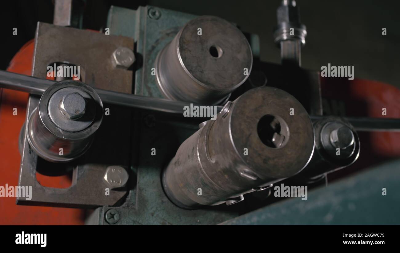 on table. Worker bends the metal rod on the wrought iron