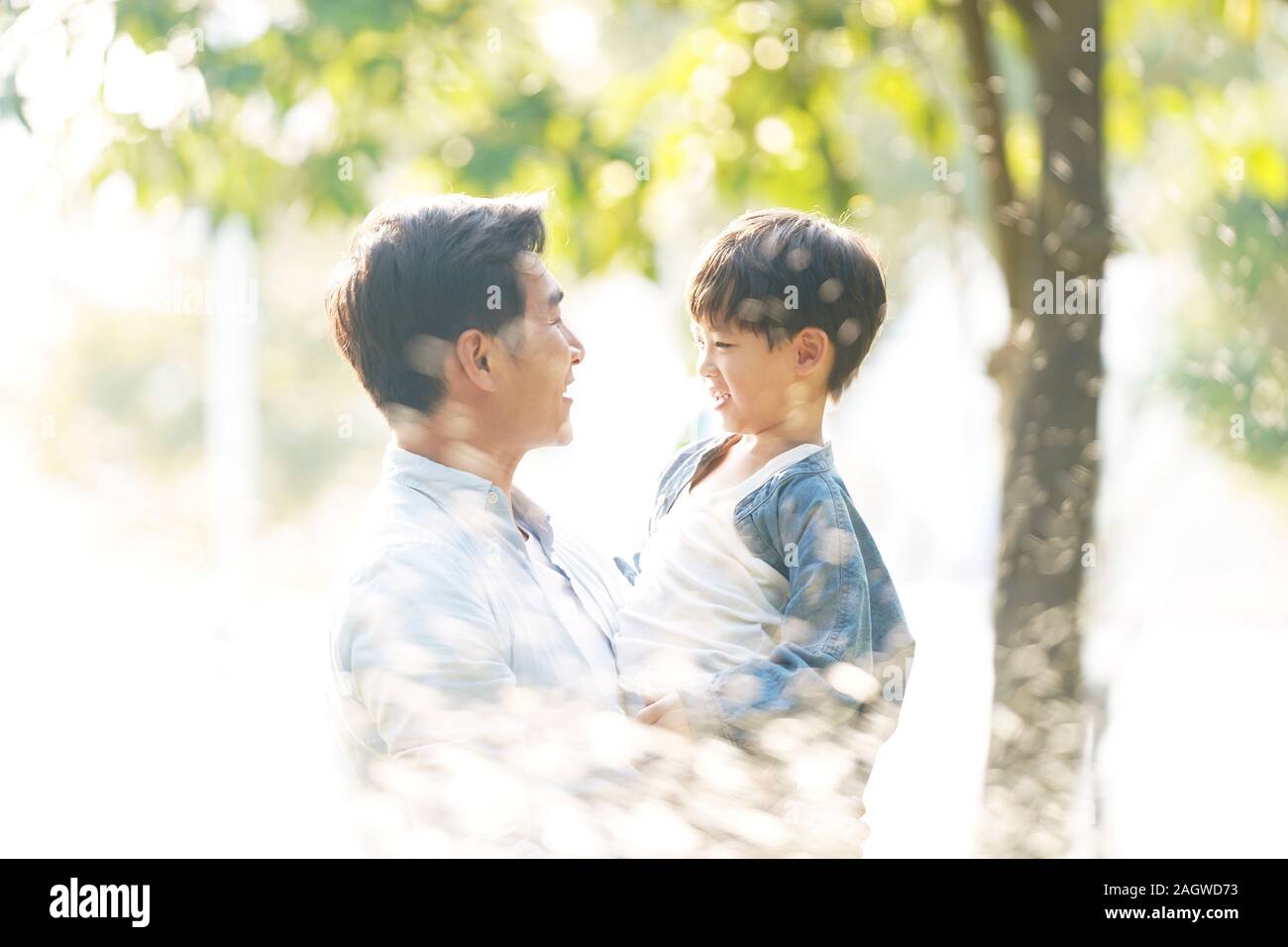 asian father and son enjoying good time outdoors in park Stock Photo